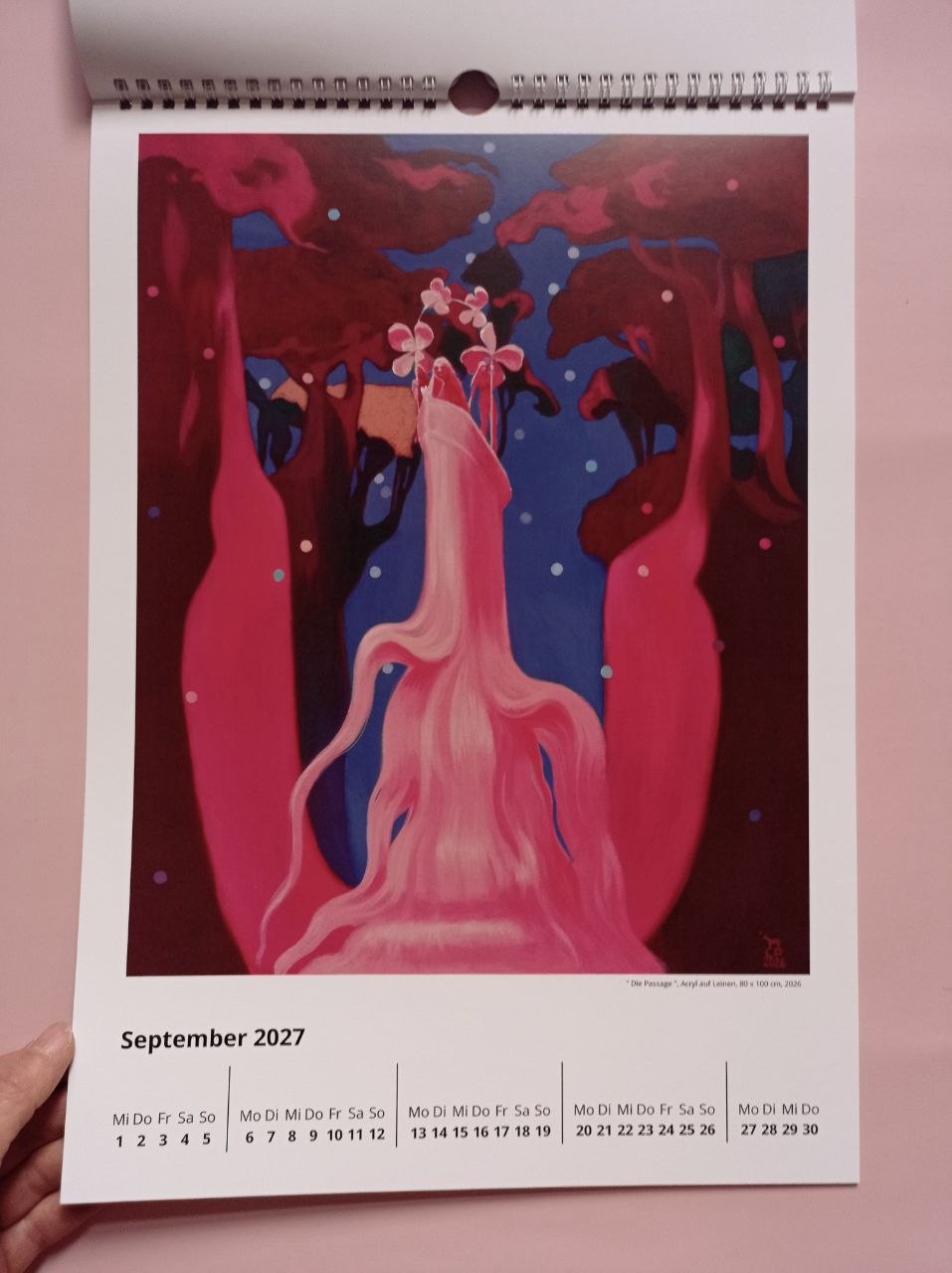 Septemberblatt 2027 mit "Die Passage": zwischen dunkelroten Bäumen hindurch, durch eine Schlucht, schwebt ein blütengekröntes Boot mit drei Frauen darin.